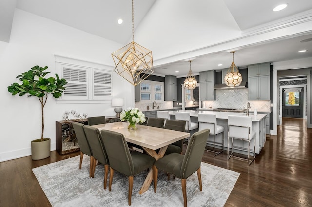 dining space with sink, a chandelier, and dark hardwood / wood-style floors