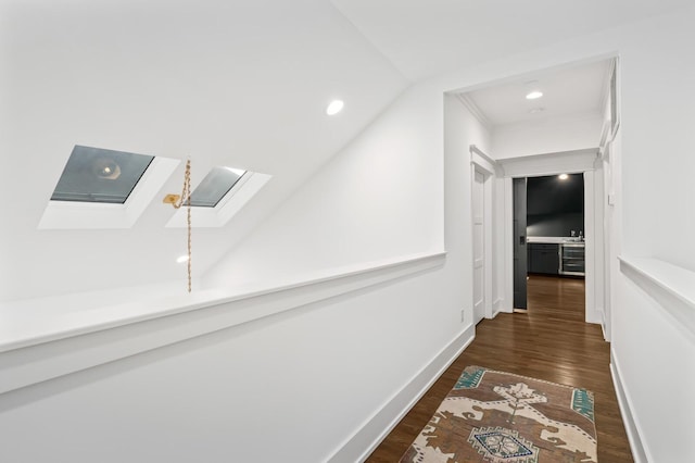 corridor featuring lofted ceiling with skylight and dark hardwood / wood-style floors