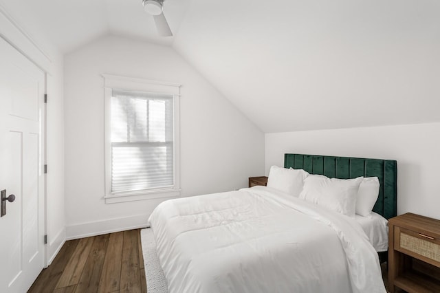 bedroom with ceiling fan, dark wood-type flooring, and vaulted ceiling