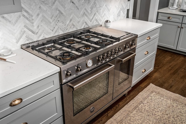 kitchen with backsplash, range with two ovens, and gray cabinets