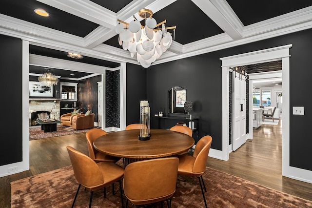 dining area featuring a fireplace, beam ceiling, and crown molding