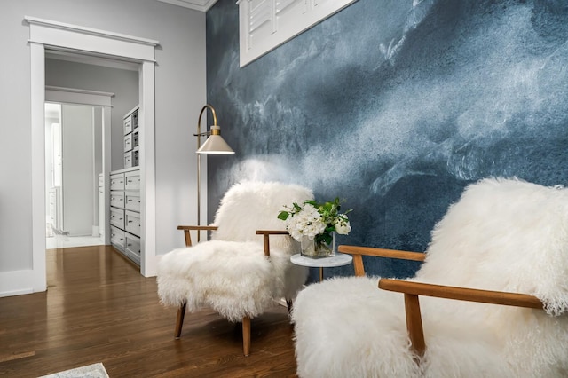 sitting room featuring ornamental molding and dark wood-type flooring