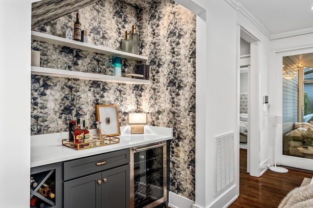 bar featuring gray cabinetry, crown molding, wine cooler, and dark wood-type flooring