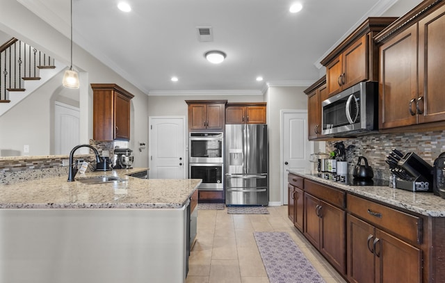 kitchen featuring kitchen peninsula, decorative light fixtures, backsplash, appliances with stainless steel finishes, and sink