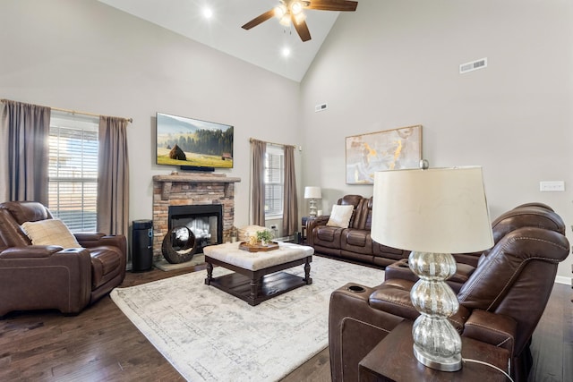 living room featuring ceiling fan, dark wood-type flooring, high vaulted ceiling, and a fireplace