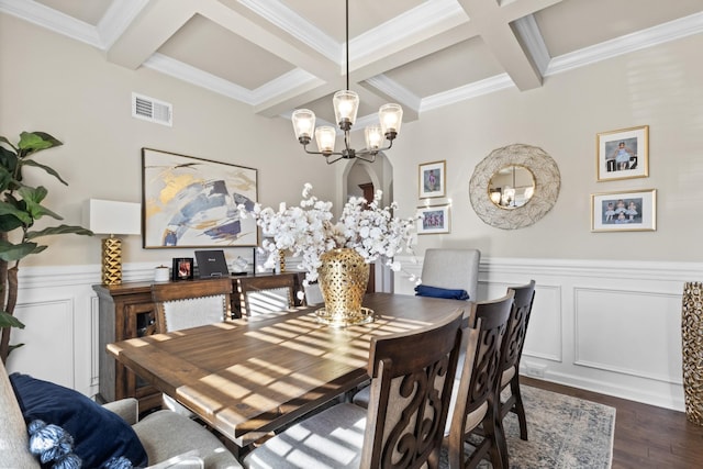 dining area featuring coffered ceiling, beamed ceiling, ornamental molding, dark hardwood / wood-style floors, and an inviting chandelier