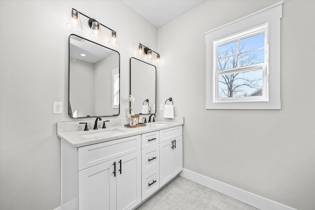 full bath featuring double vanity, tile patterned flooring, baseboards, and a sink