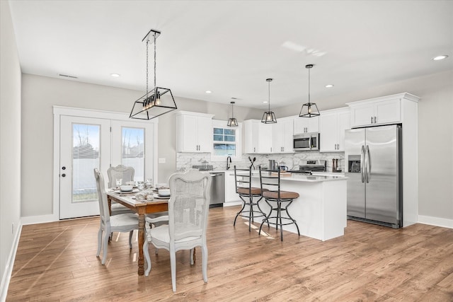 dining area with light wood finished floors, visible vents, recessed lighting, and baseboards