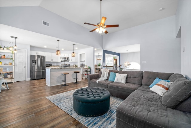 living room with vaulted ceiling, ceiling fan, and dark wood-type flooring