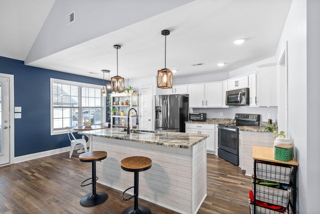 kitchen featuring white cabinets, vaulted ceiling, appliances with stainless steel finishes, and sink