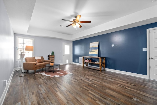 living room featuring ceiling fan, radiator, dark hardwood / wood-style floors, and a tray ceiling