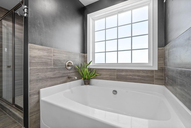 bathroom featuring independent shower and bath