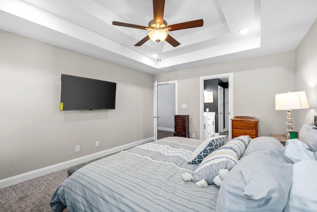 bedroom featuring ceiling fan, carpet floors, and a tray ceiling