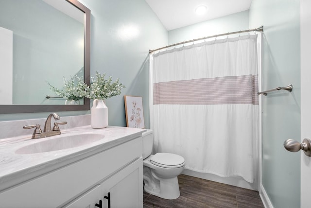 bathroom featuring wood-type flooring, toilet, and vanity