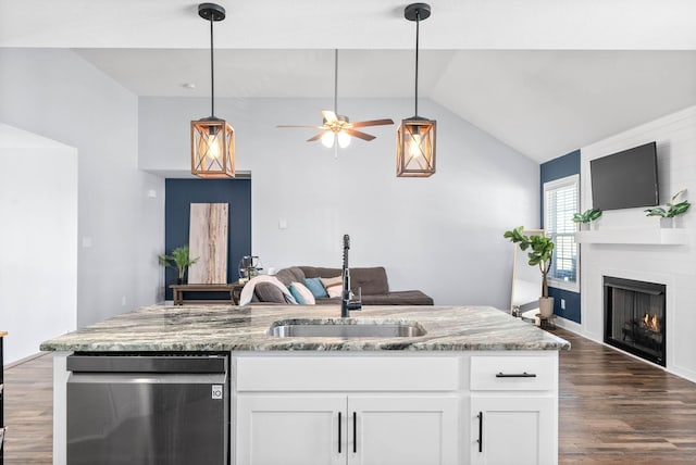 kitchen with stainless steel dishwasher, sink, light stone counters, and white cabinetry