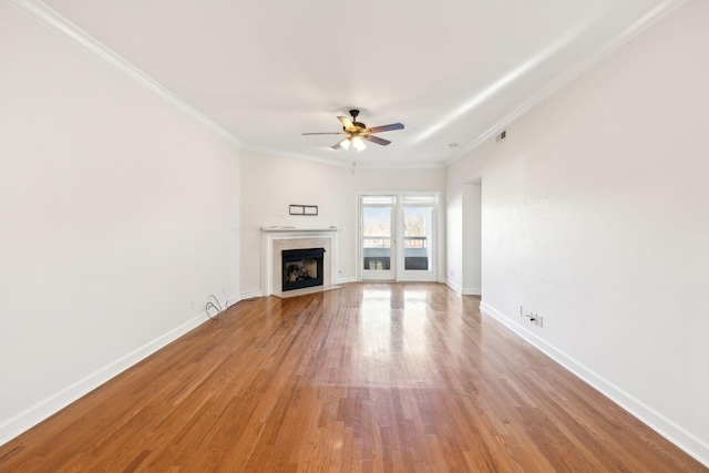 unfurnished living room featuring ceiling fan, light hardwood / wood-style floors, and ornamental molding