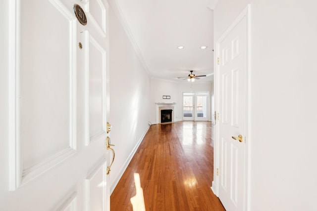 hallway with hardwood / wood-style floors and crown molding