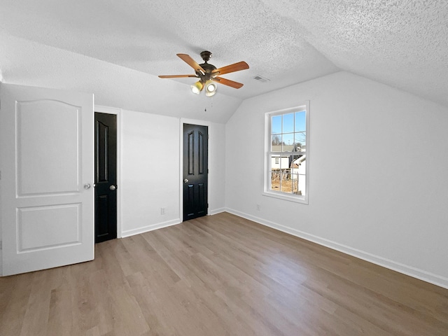 interior space featuring lofted ceiling, a textured ceiling, ceiling fan, and light hardwood / wood-style floors