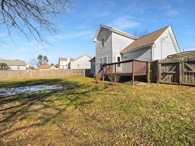 rear view of house with a yard and a wooden deck