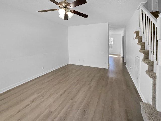 unfurnished living room featuring ceiling fan and hardwood / wood-style floors