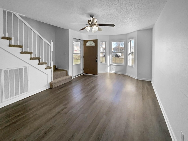 entryway featuring a textured ceiling, ceiling fan, and dark wood-type flooring