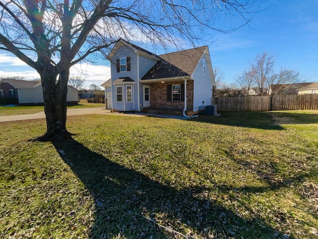 view of front of property with a front yard and central AC