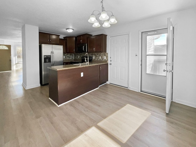 kitchen featuring stainless steel appliances, decorative light fixtures, kitchen peninsula, and dark brown cabinetry