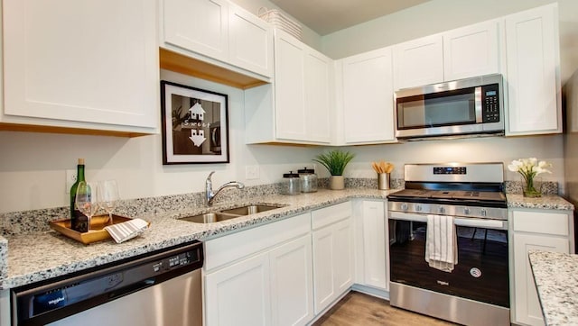 kitchen featuring stainless steel appliances, white cabinets, and sink