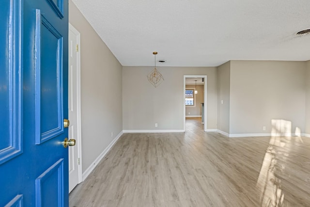 foyer entrance featuring light wood-type flooring and a textured ceiling