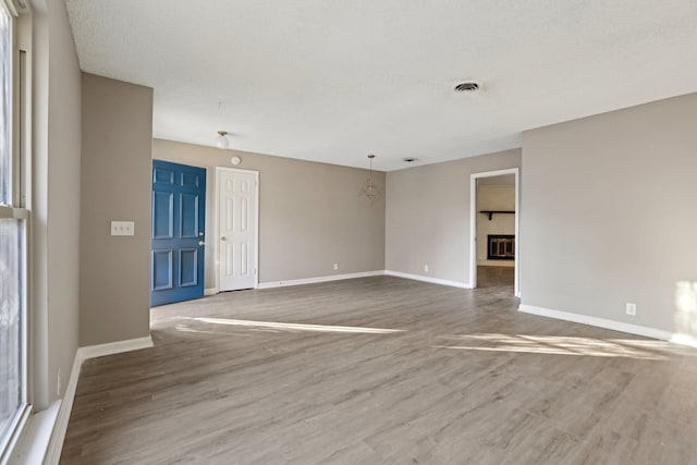 unfurnished room with wood-type flooring and a notable chandelier