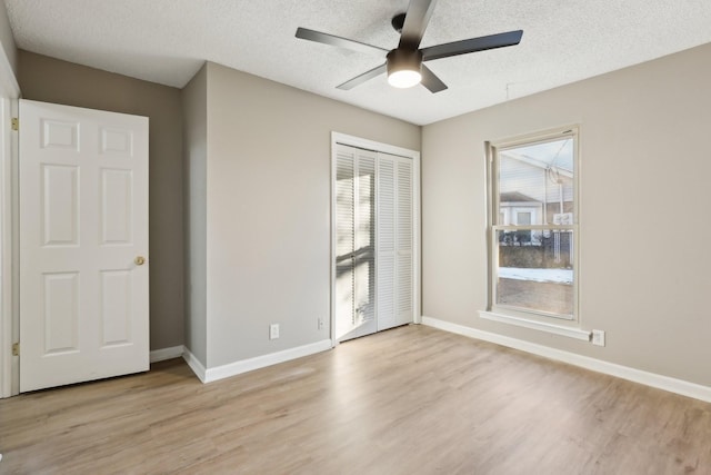 unfurnished room with light hardwood / wood-style floors, a textured ceiling, and ceiling fan