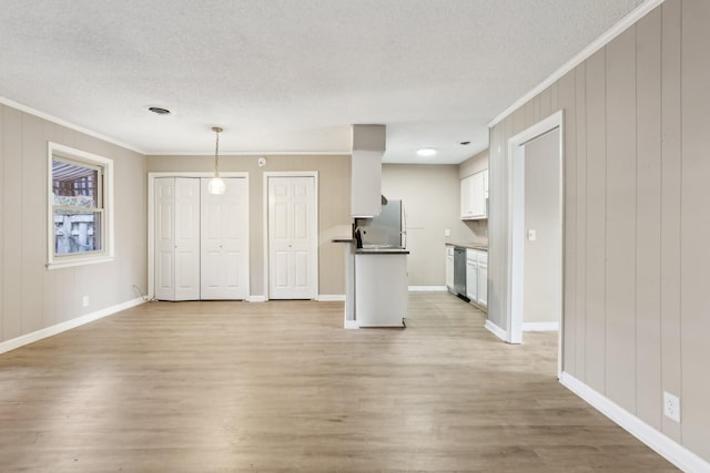 unfurnished living room featuring light wood-type flooring, a textured ceiling, and crown molding