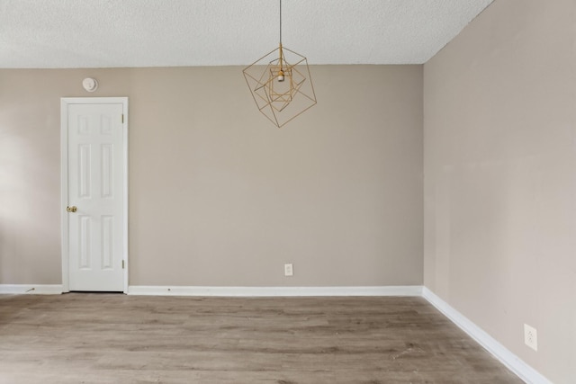 empty room with wood-type flooring and a textured ceiling