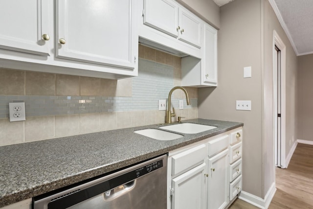 kitchen featuring tasteful backsplash, dishwasher, light hardwood / wood-style floors, sink, and white cabinets