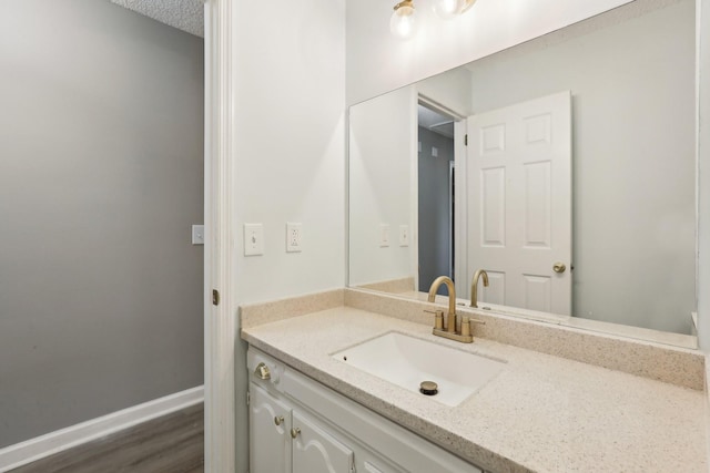 bathroom with a textured ceiling, vanity, and hardwood / wood-style floors