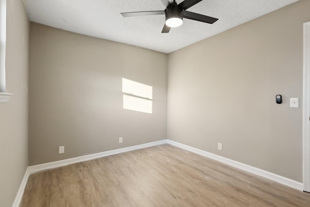 empty room with a textured ceiling, ceiling fan, and light hardwood / wood-style floors