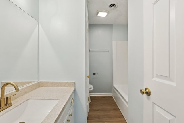 bathroom featuring toilet, hardwood / wood-style floors, and vanity