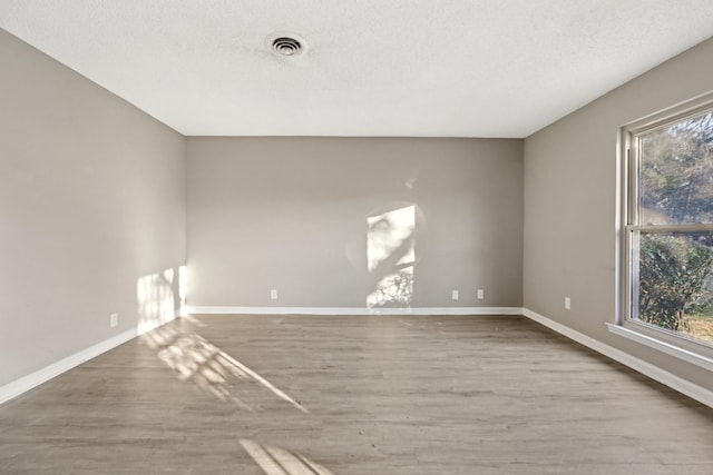 unfurnished room featuring a textured ceiling and hardwood / wood-style floors