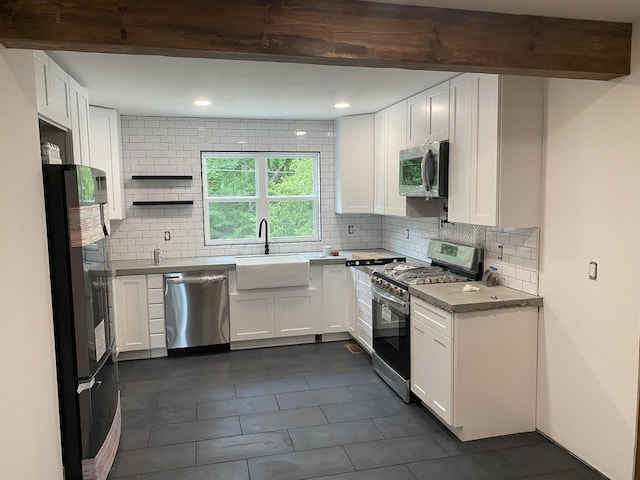 kitchen featuring beam ceiling, appliances with stainless steel finishes, tasteful backsplash, and white cabinetry