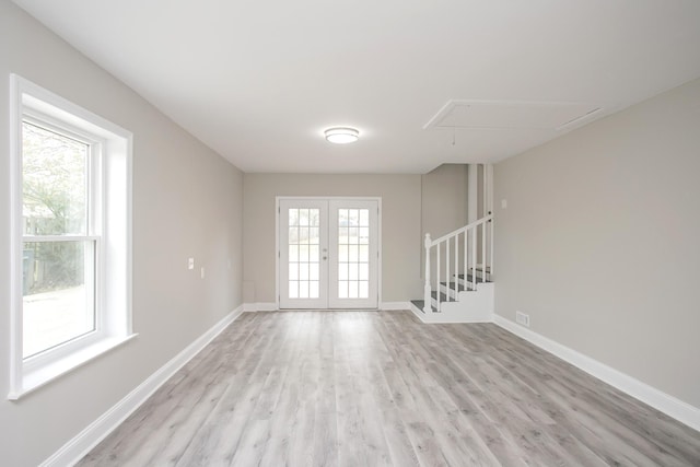 unfurnished room with french doors, light wood-type flooring, and a wealth of natural light