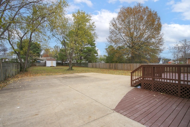 wooden deck featuring a patio area, a lawn, and a shed