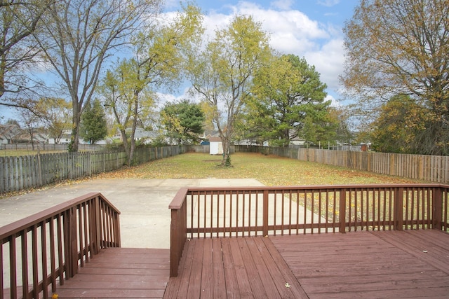 wooden terrace featuring a yard and a storage shed