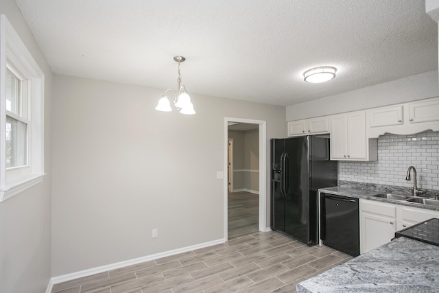 kitchen with sink, black appliances, pendant lighting, and white cabinetry