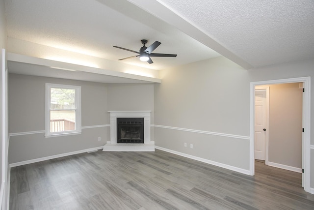 unfurnished living room featuring a textured ceiling, ceiling fan, and hardwood / wood-style flooring