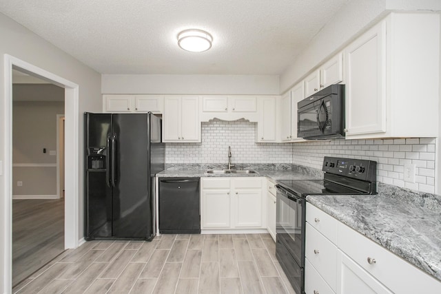 kitchen featuring black appliances, white cabinets, a textured ceiling, and sink