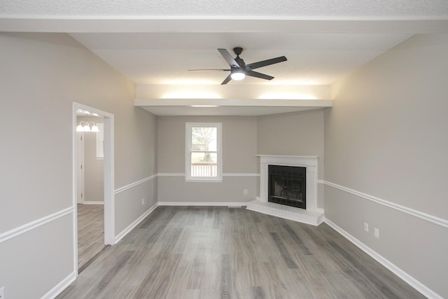 unfurnished living room featuring a brick fireplace, ceiling fan, and wood-type flooring