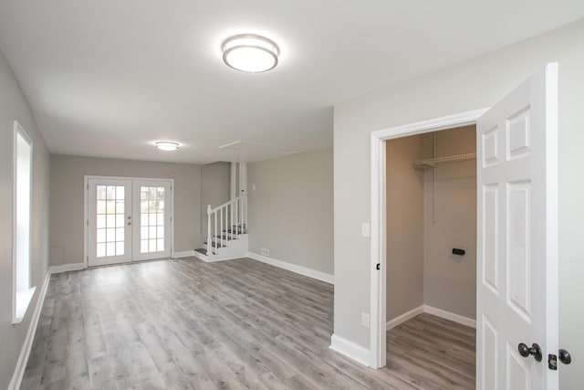 empty room with french doors and light wood-type flooring