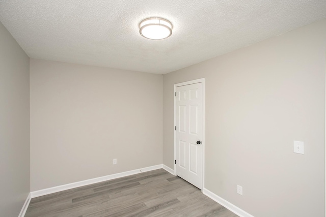 spare room with a textured ceiling and wood-type flooring