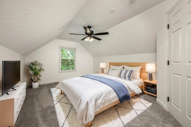 carpeted bedroom with vaulted ceiling, a textured ceiling, and ceiling fan