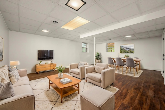 living room featuring a paneled ceiling and hardwood / wood-style floors